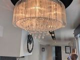 un homme debout dans une cuisine, avec un lustre suspendu au plafond