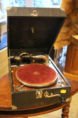 un ours en peluche posé sur une table à côté d'un vieux tourne-disque
