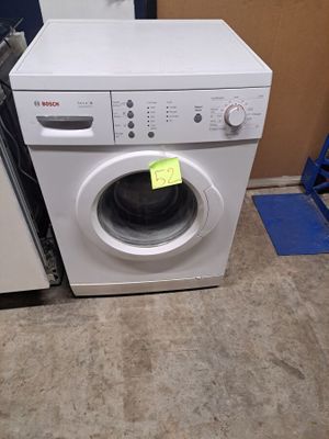 une machine à laver et un sèche-linge placés l'un à côté de l'autre dans une pièce