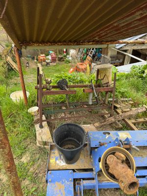 a bucket of food sitting on the ground next to a blue machine