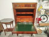a small desk with a glass top and a small table with two chairs