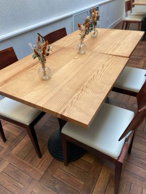 a wooden table with four chairs and a vase of flowers on it