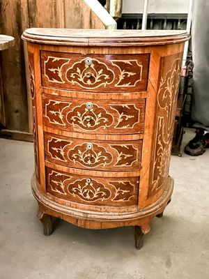 a wooden chest of drawers in a room with a stair case