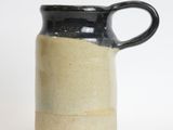 a black and white jug with a handle on a white surface