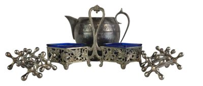 a silver tea pot and two blue cups on a stand