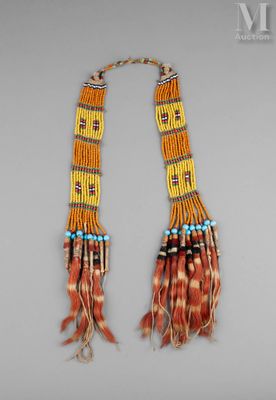 un gros plan d'un collier orné de plumes et de perles