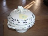 a white bowl with blue flowers on it sitting on a table