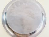 a silver plate on a table with a white background