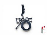 the necklace is made of black metal and has a dog ' s number on it