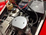 a red car with an engine in it ' s trunk