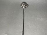 a silver spoon with a handle on a white surface