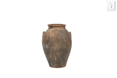un vase brun posé sur une surface blanche