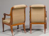 pair of chairs with upholstered arms and a cane back