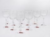 a set of six wine glasses with red rims on a white background