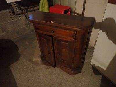 un petit meuble en bois dans un coin de la pièce