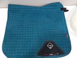 the blue saddle pad is sitting on the counter next to a bowl