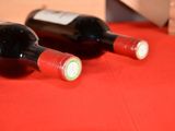 two bottles of wine sitting on a red table