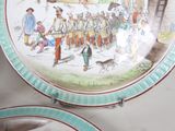 two plates with a painting on them on a table