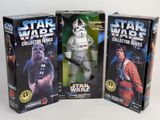 three star wars action figures in boxes on a white surface