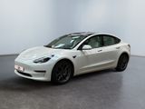 une Tesla Model 3 blanche garée dans une pièce blanche