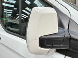 a side view mirror of a white van parked in a parking lot