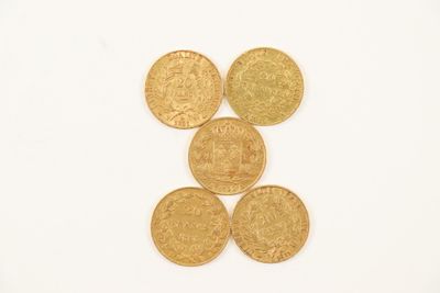 four gold coins sitting on top of each other on a white surface
