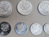 Six types différents de pièces d'argent sont disposés sur une table.
