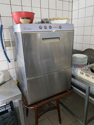 un lave-vaisselle et une cuisinière en acier inoxydable dans une cuisine aux murs carrelés