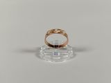 a close up of a gold ring on a clear stand