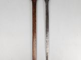 two swords with wooden handles on a white surface