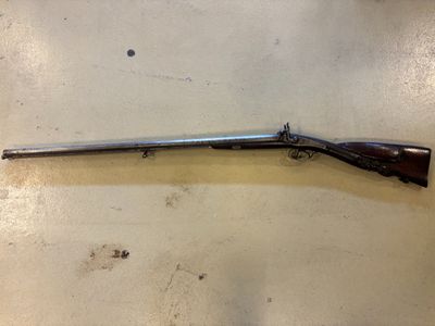 un vieux fusil fixé au mur d'une pièce