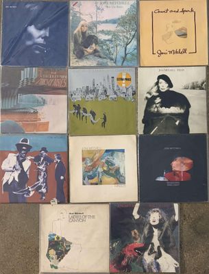 various album covers are arranged on the floor in a room