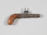un vieux pistolet avec une poignée en bois sur une surface blanche
