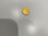 une pièce d'or posée sur une table blanche