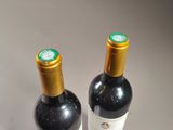 two bottles of wine sitting next to each other on a table