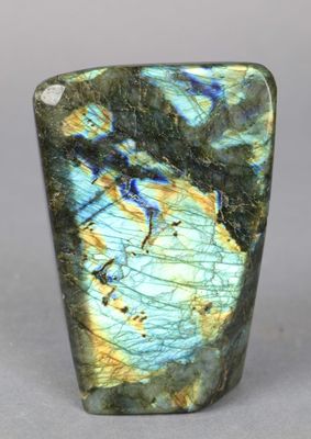 a close up of a green and blue stone on a gray surface