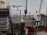 a kitchen with a sink and a lot of utensils on the counter