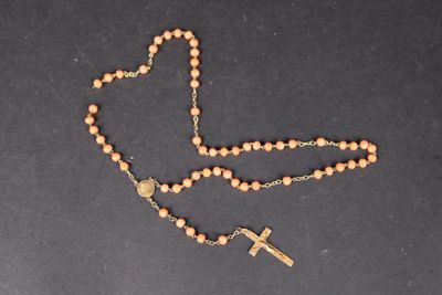 un chapelet orné d'une croix, posé sur une table