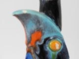 a vase with a fish on it sitting on a table