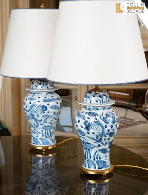 deux vases bleus et blancs posés sur une table avec des lampes