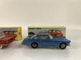 two toy cars are sitting next to each other on a white surface