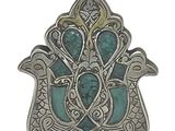 un gros plan d'un pendentif en argent et turquoise monté sur une chaîne