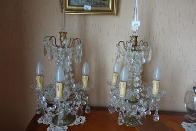 deux lustres en cristal posés sur une table, avec un tableau en arrière-plan