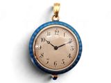 une petite horloge bleue accrochée à un mur blanc