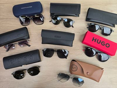 a lot of sunglasses that are laying out on the table