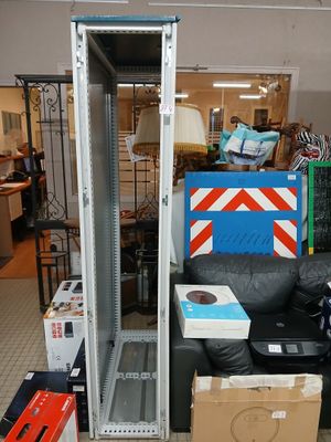 a room with a couch, a chair, a table, and a metal rack