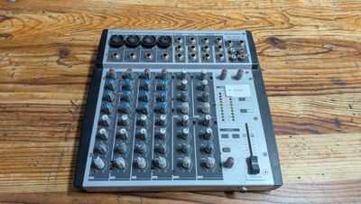 une console de mixage posée sur une table en bois