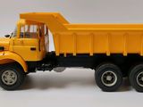 yellow toy dump truck on a white background with a blue sign