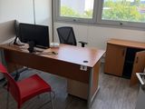 a desk with a computer and a chair in a room