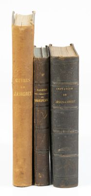 trois vieux livres posés l'un sur l'autre sur une surface blanche